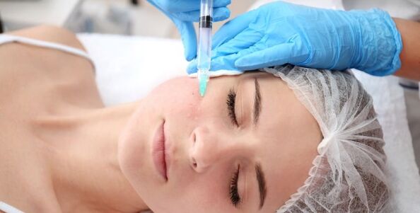 A beautician performs facial skin rejuvenation using plasma